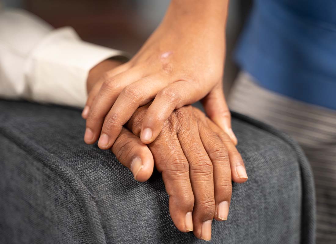 Final Expense Insurance - Close-up of Doctor Holding Hands of a Senior Patient to Show Sympathy and Kindness to Offer Condolences